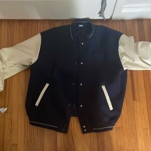 Navy blue and white letterman jacket, faux leather sleeves, soft torso.